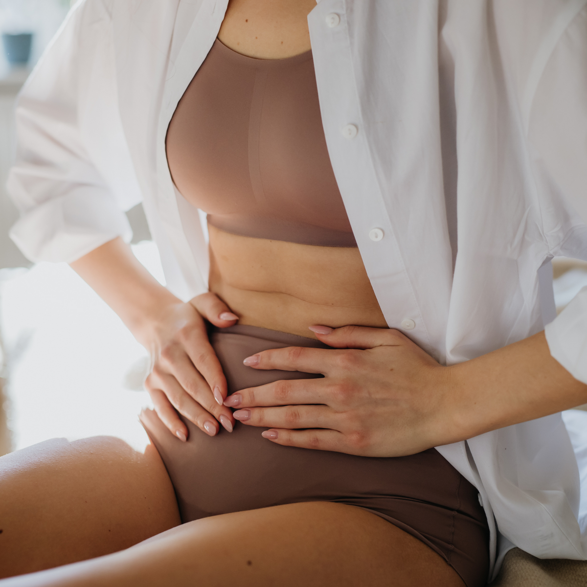 Woman resting her hands on her abdomen