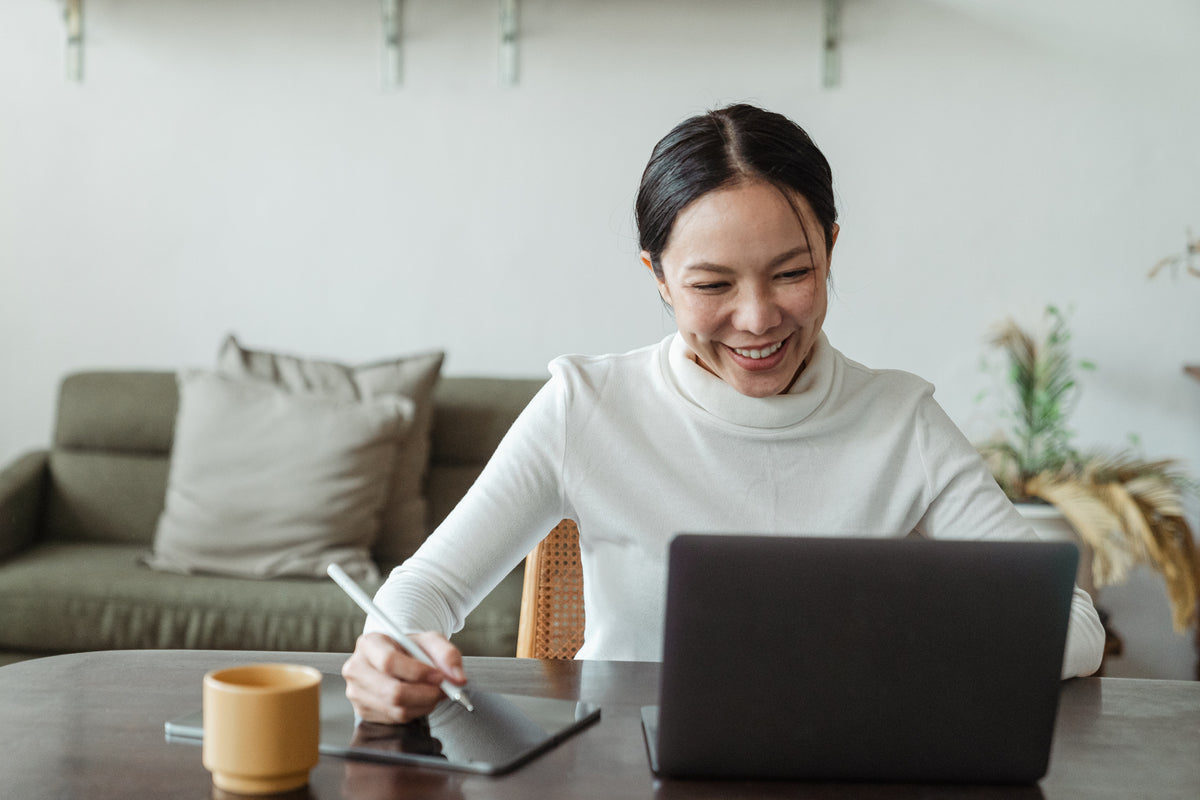 Woman smiling at her laptop during an online session at home