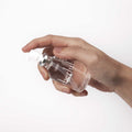 Hand pressing the pump on a 55 ml Überlube silicone lubricant bottle