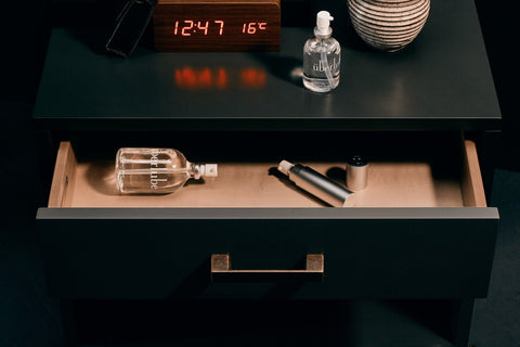 Überlube silicone lubricant bottles on a nightstand and in the drawer